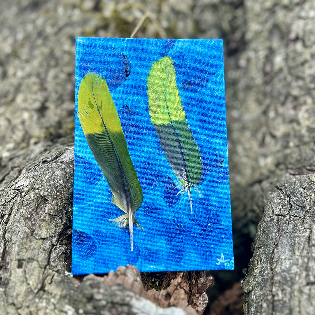 Acrylbild mit zwei grün-gelben Federn auf blauem Hintergrund