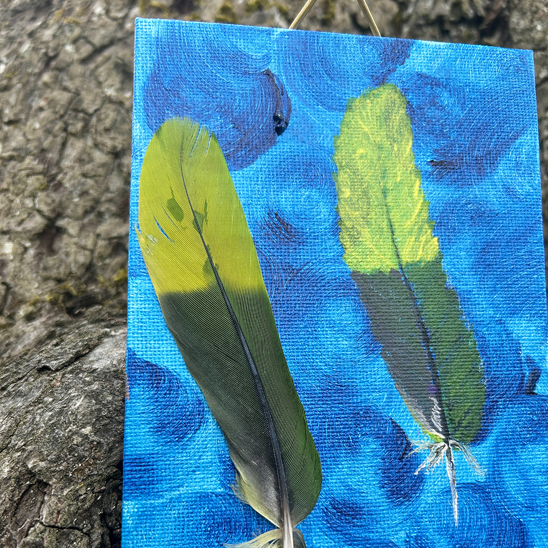 Acrylbild mit zwei grün-gelben Federn auf blauem Hintergrund